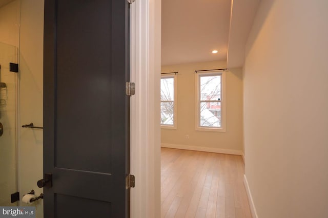 corridor with light wood finished floors, recessed lighting, and baseboards