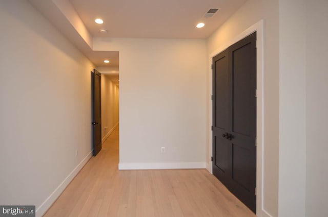 corridor with light wood-style floors, baseboards, visible vents, and recessed lighting