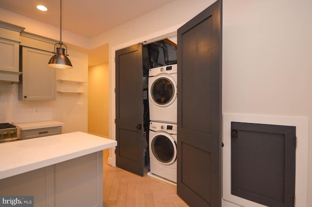 laundry room featuring stacked washer and dryer, recessed lighting, and laundry area