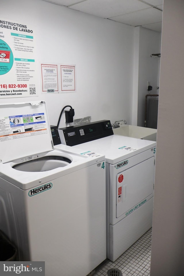 common laundry area featuring washing machine and dryer, a sink, and light tile patterned flooring