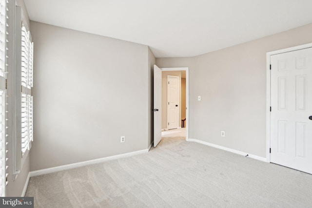 unfurnished bedroom with light carpet and baseboards