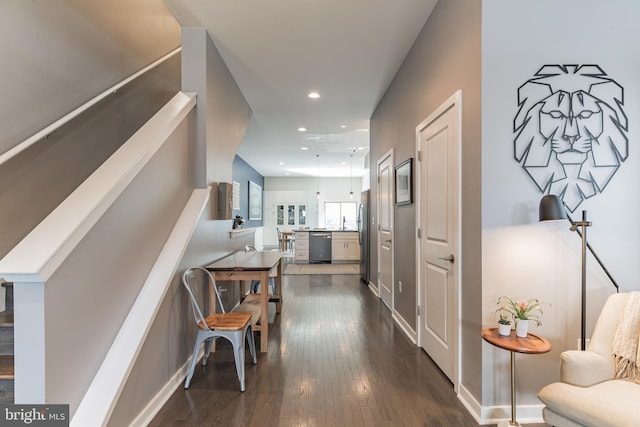 corridor with dark wood-style floors, stairs, baseboards, and recessed lighting