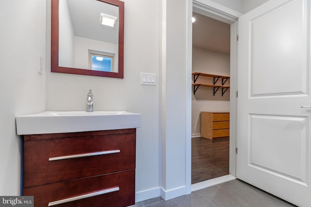 bathroom with tile patterned floors, vanity, and baseboards