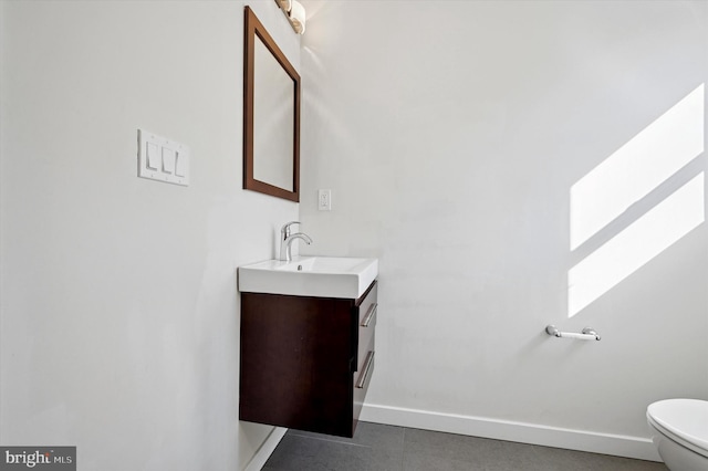 bathroom featuring toilet, baseboards, and vanity