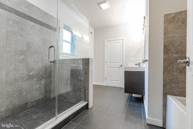 full bath with a stall shower, tile patterned flooring, baseboards, and vanity