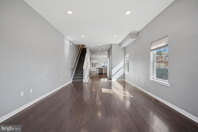 unfurnished living room featuring stairs, baseboards, dark wood finished floors, and recessed lighting