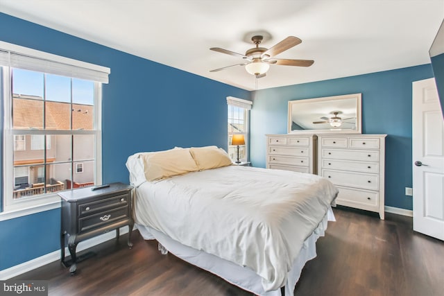 bedroom with dark wood-style floors, a ceiling fan, and baseboards