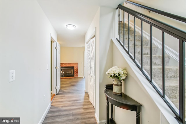 corridor with stairs, baseboards, and wood finished floors