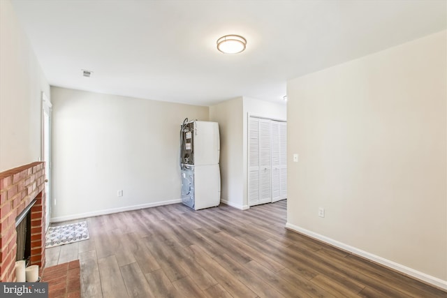 unfurnished living room featuring visible vents, a fireplace, baseboards, and wood finished floors