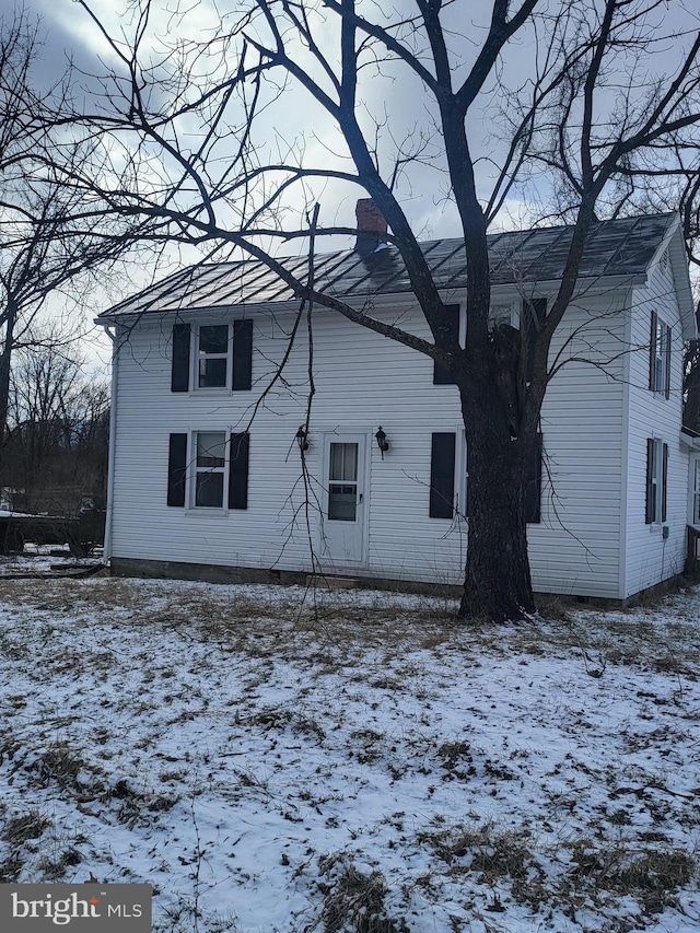 view of snow covered rear of property