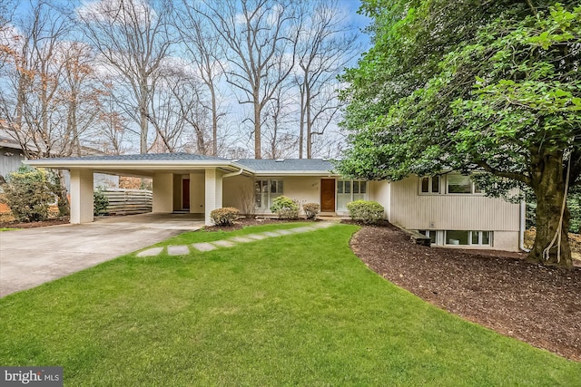 view of front facade featuring an attached carport, concrete driveway, brick siding, and a front yard