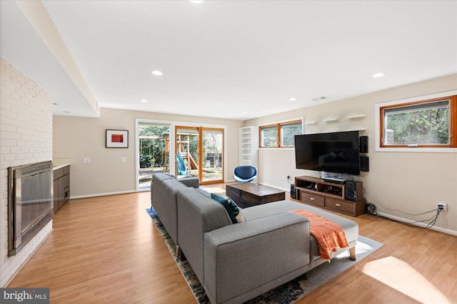 living area featuring baseboards, recessed lighting, and light wood-style floors