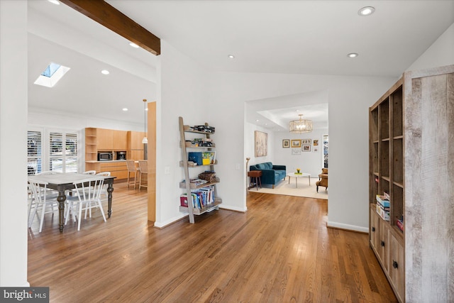 entryway with lofted ceiling with skylight, wood finished floors, and recessed lighting