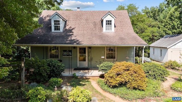 cape cod home featuring covered porch and a shingled roof