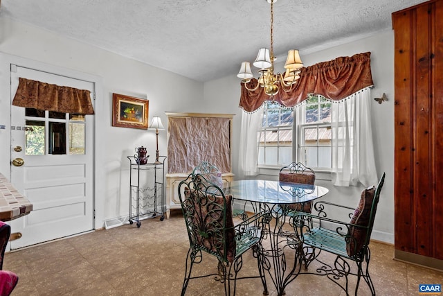 dining area featuring a chandelier, baseboards, a textured ceiling, and light floors