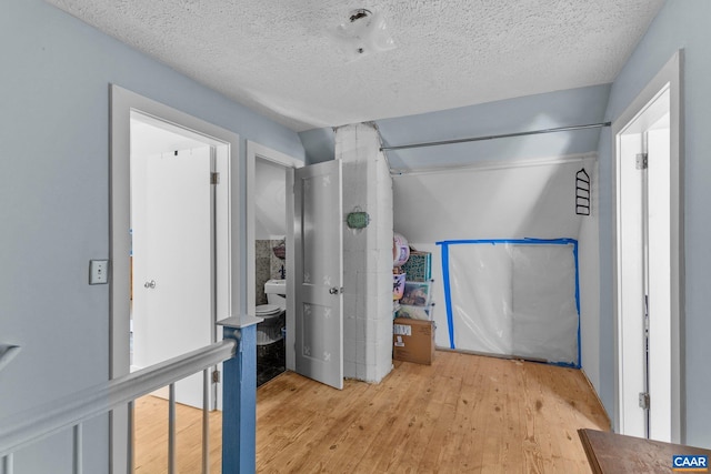 interior space with a textured ceiling and light wood-style flooring