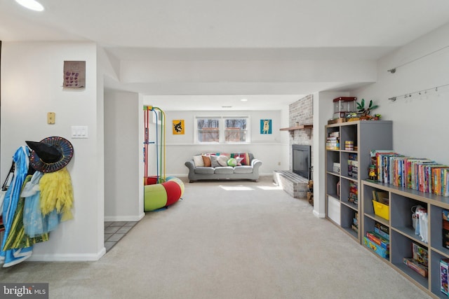 playroom with carpet, a fireplace, and baseboards