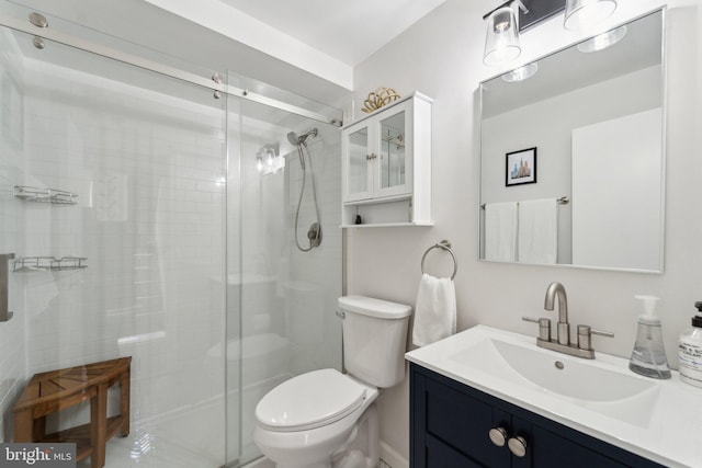 full bathroom with a stall shower, vanity, and toilet