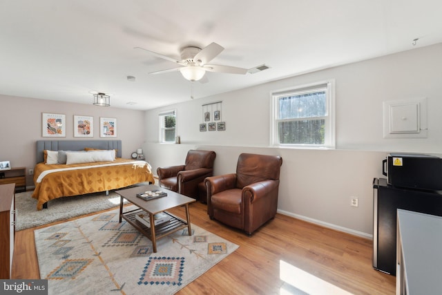 bedroom featuring light wood-style flooring, visible vents, and baseboards