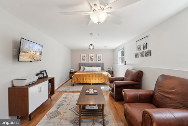 bedroom featuring ceiling fan, light wood-type flooring, and baseboards