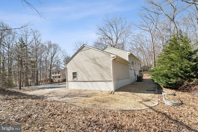 view of side of property with driveway and central AC unit