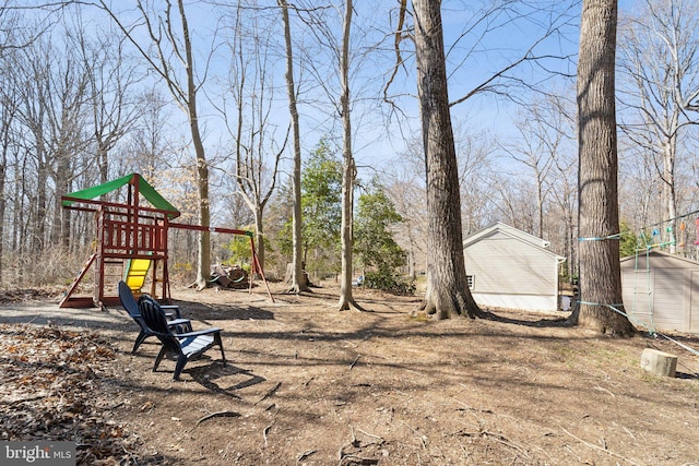 view of yard featuring a storage shed, a playground, and an outdoor structure