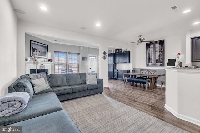 living area with visible vents, baseboards, ceiling fan, light wood-type flooring, and recessed lighting