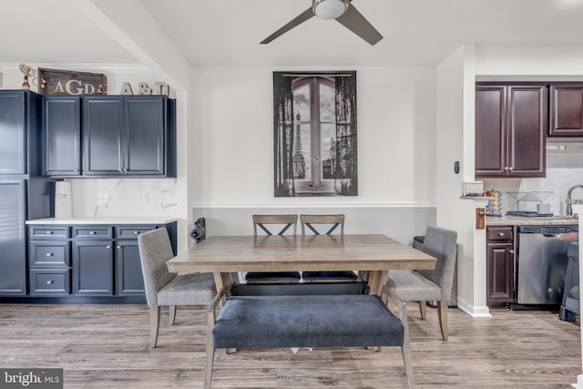 dining area with a ceiling fan and light wood-style floors