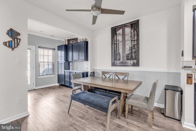 dining space featuring light wood-type flooring, ceiling fan, and baseboards