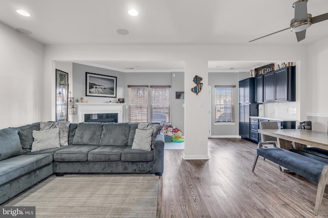 living room with recessed lighting, a glass covered fireplace, ceiling fan, wood finished floors, and baseboards