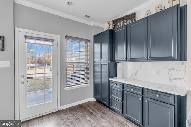 kitchen with dark wood-style floors, visible vents, backsplash, ornamental molding, and baseboards