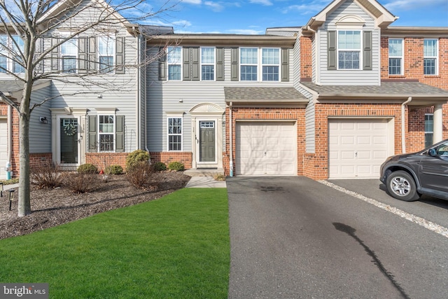 multi unit property featuring brick siding, a shingled roof, an attached garage, driveway, and a front lawn