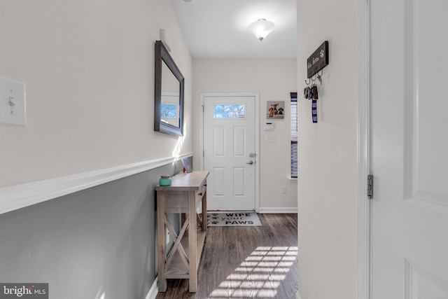 doorway featuring dark wood-style floors and baseboards