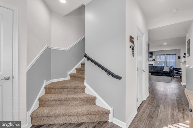 staircase with recessed lighting, wood finished floors, and baseboards