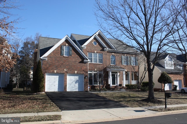 view of front of property featuring aphalt driveway, brick siding, and an attached garage