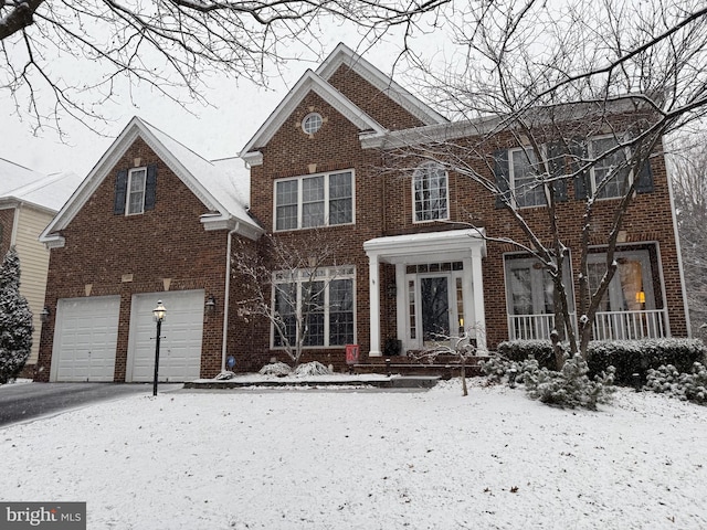 view of front of home with a garage, aphalt driveway, and brick siding