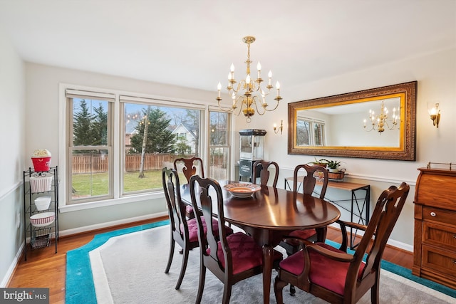 dining room featuring wood finished floors, baseboards, and a chandelier