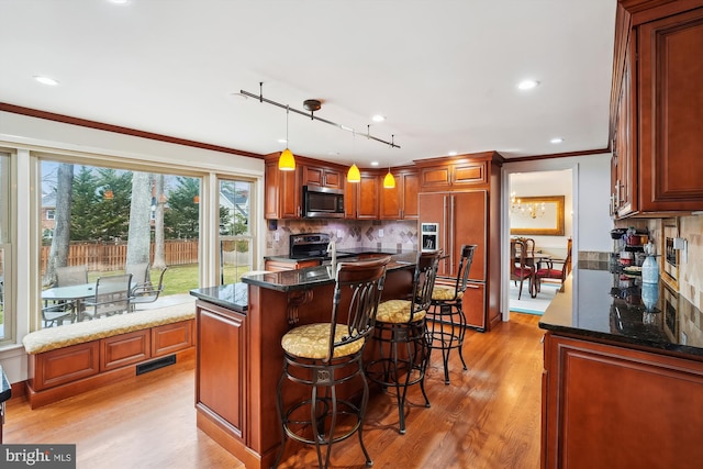 kitchen with tasteful backsplash, visible vents, crown molding, appliances with stainless steel finishes, and light wood-style floors