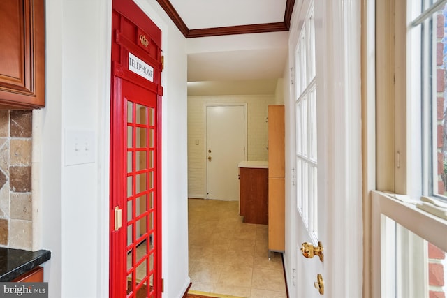 hallway with light tile patterned flooring and ornamental molding