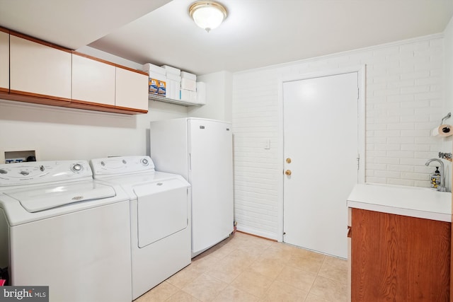 washroom with washer and clothes dryer and cabinet space