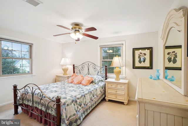 bedroom featuring visible vents, light carpet, multiple windows, and baseboards