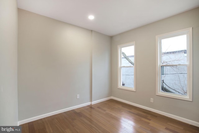 empty room with baseboards and wood finished floors