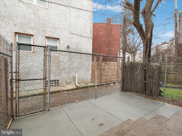 view of property exterior featuring fence, a gate, and stucco siding