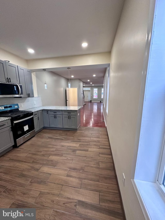 kitchen featuring dark wood-style floors, stainless steel appliances, recessed lighting, gray cabinetry, and a peninsula