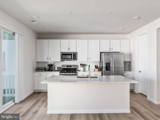 kitchen featuring appliances with stainless steel finishes, light countertops, white cabinetry, and a sink