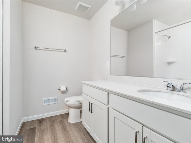 bathroom featuring baseboards, visible vents, toilet, and wood finished floors