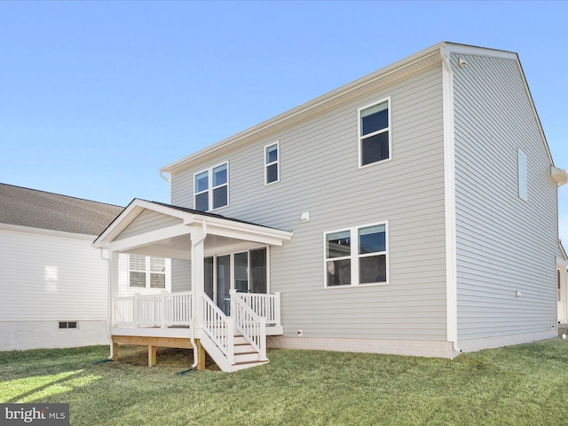 rear view of house featuring a sunroom and a lawn