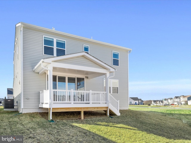 view of front of home with covered porch, a front lawn, and central AC unit