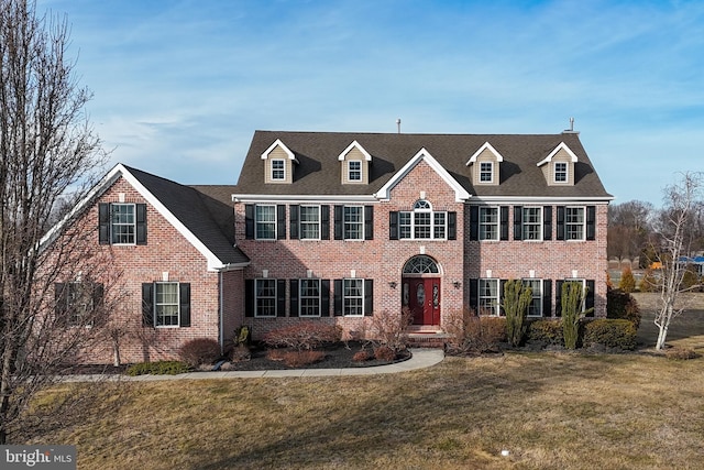 view of front of house featuring brick siding and a front yard