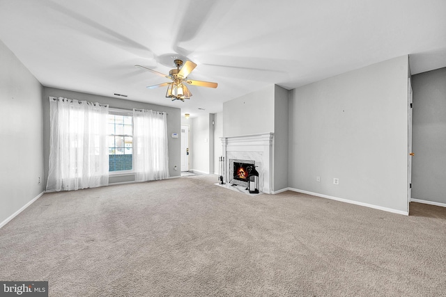 unfurnished living room featuring baseboards, visible vents, a ceiling fan, carpet flooring, and a fireplace